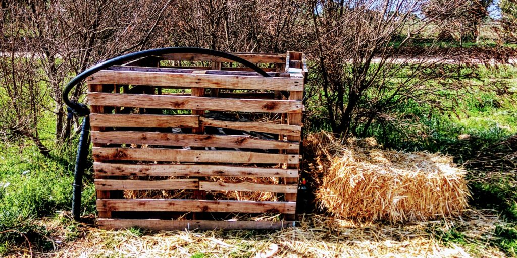 An image of the first wooden pallet composting bin built by Marlon & Alexia. One more way to compost everything